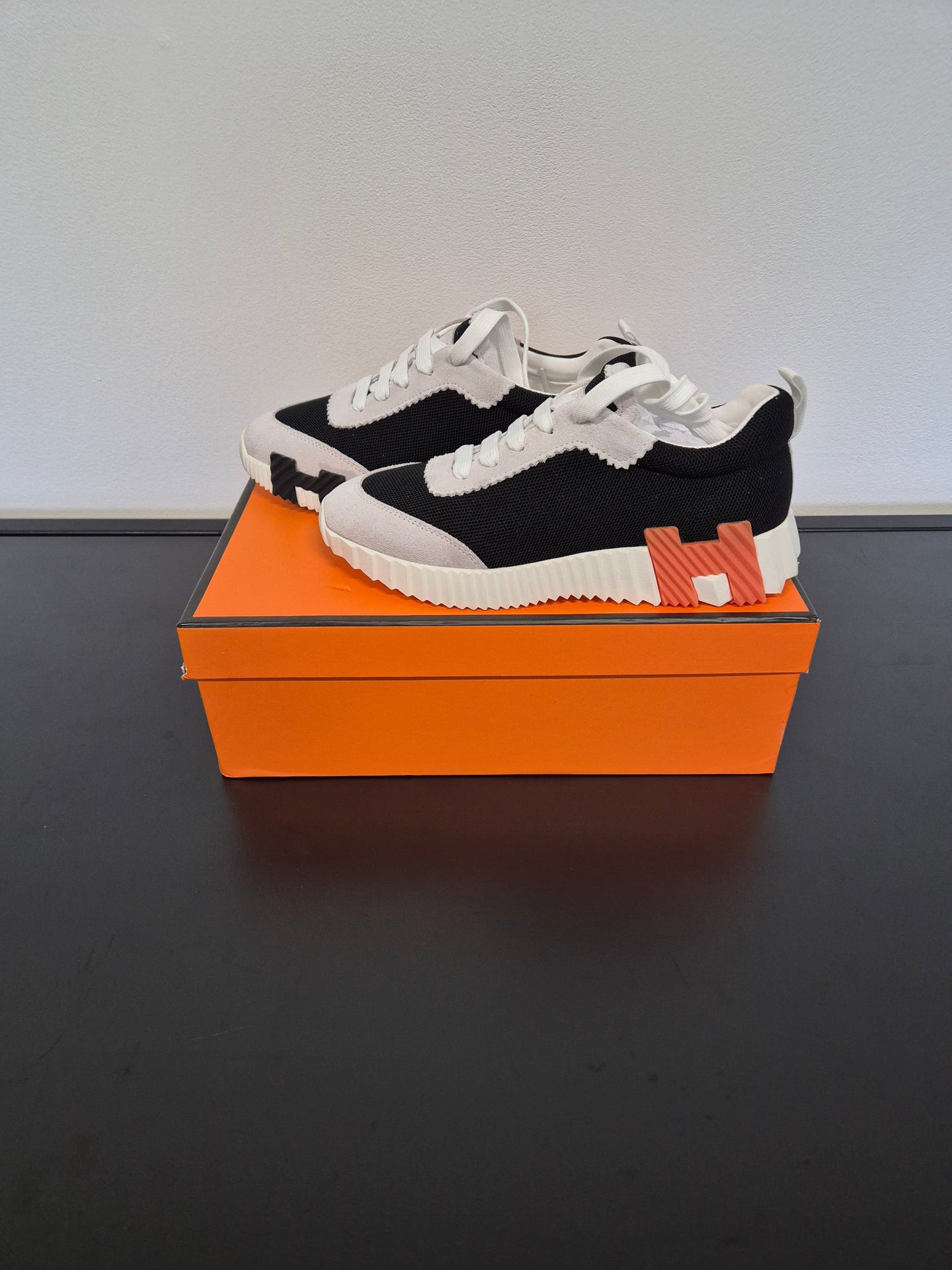 DAMES SCHOENEN Hermès Bouncing Sneaker In Canvas en suède zwart, wit en oranje